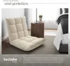 A beige floor chair is placed in a bedroom setting next to a bedside table and a bed. Náhled obrázku produktu