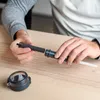 A person is assembling a water filter bottle on a wooden table. Náhled obrázku produktu