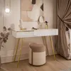 A modern vanity set with a white console table and a beige upholstered stool, decorated with a bust and makeup brushes. Produktbild-Vorschau