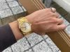 A person's wrist wearing a gold Tissot watch, with a ring on one finger. Anteprima dell’immagine prodotto
