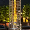 A patio heater is lit and providing warmth on a patio at night, with greenery and city lights in the background. Produktbild-Vorschau