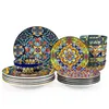 A collection of colorful, patterned ceramic plates and bowls arranged on a white background. Náhled obrázku produktu