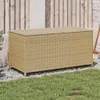 A beige poly rattan storage box is placed on gravel in front of a wooden fence and a grassy area. Náhled obrázku produktu