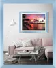 A living room scene with a pink sofa, coffee table, and a framed picture on the wall. Produktbild-Vorschau