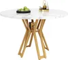 A round dining table with a marble-effect top and gold legs, set against a white background. Decorative items like green apples and bottles are on the table. Voir les images du produit
