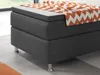 A close-up view of a box spring bed with a patterned blanket. Produktbild-Vorschau