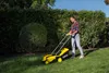 A woman is mowing a lawn with a yellow and black Kärcher lawnmower. Produktbild-Vorschau