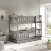 A grey wooden bunk bed with a pull-out drawer, set up in a child's room with toys and a window view. Produktbild-Vorschau