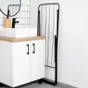 A modern bathroom vanity with a sink and a black folding drying rack next to it. Voir les images du produit