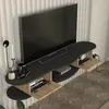 A modern TV lowboard mounted on a wall, with a TV placed on it. The lowboard has two closed compartments and one open shelf. Decorative items like a candle holder and a vase are on the top surface. Podgląd zdjęcia produktu