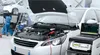 Car repair shop with a white car being serviced and a diagnostic machine. Voir les images du produit