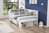 A white bed with built-in storage shelves and a headboard filled with books and decorative items, set against a dark blue wall and a window overlooking a garden. Produktbild-Vorschau