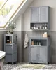 A bathroom with grey tiled walls and patterned floor, featuring several grey storage cabinets and a bathtub. There is a window with natural light coming through. Náhled obrázku produktu