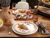 A beautifully set table with plates, wine glasses, and food, suggesting a dining experience. Náhľad obrázku produktu