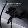 A close-up shot of a black bathroom faucet mounted on a textured gray wall. Produktbild-Vorschau