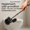 A hand holding a toilet brush over a toilet bowl. Anteprima dell’immagine prodotto