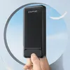 A hand is holding a black power bank against a light blue sky background with feathers floating around. Náhled obrázku produktu
