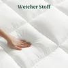 Hand drückt auf gesteppten Topper – demonstriert Rückstellkraft und Komfort.
 Produktbild-Vorschau