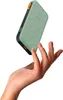 A hand is holding a sage green power bank. Voir les images du produit