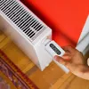 A hand is shown adjusting a smart thermostat on a radiator. Náhľad obrázku produktu