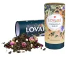 A pile of loose green tea with dried rose buds and white pieces, next to a cylindrical tea container. Another similar container is lying on its side in the background. Anteprima dell’immagine prodotto