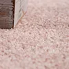 A close-up of a pink rug with a wooden object in the foreground. Produktbild-Vorschau