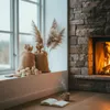 A cozy indoor scene with a fireplace, a window, and a book with a mug. Anteprima dell’immagine prodotto