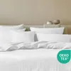 A neatly made bed with white linen bedding and pillows. Podgląd zdjęcia produktu