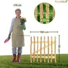 A woman is holding a potted plant and gardening tools next to a wooden fence gate. Dimensions are indicated with text overlays. Produktbild-Vorschau