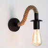 A single wall lamp with a black base and a flexible rope arm holding a light bulb. Náhľad obrázku produktu