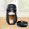 A black Bosch Tassimo coffee machine making a latte, with the drip tray to the side. Voir les images du produit