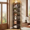 A tall, narrow corner bookshelf filled with decorative items and books, placed next to a window and a nightstand with a lamp. Podgląd zdjęcia produktu