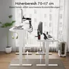 Two adjustable height desks are shown in a well-lit room with large windows and sheer curtains. One desk is set to its maximum height (117cm) and the other to its minimum height (70cm), illustrating the height range. The desks are equipped with monitors, k Anteprima dell’immagine prodotto