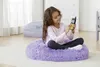 A young girl sits on a fluffy purple beanbag chair, holding a yellow and black walkie-talkie. Produktbild-Vorschau