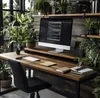 A desk setup with a monitor stand, computer, plants, and chair. Podgląd zdjęcia produktu
