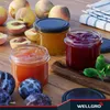 Three jars of jam and some fresh fruit are arranged on a wooden surface. Produktbild-Vorschau