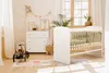 A nursery room with a crib, dresser, and toys. Produktbild-Vorschau