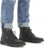 A close-up shot of a person's legs wearing blue jeans and black leather boots. Voir les images du produit