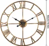 A close-up of a large, vintage-style metal wall clock with Roman numerals. Produktbild-Vorschau