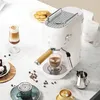 A white espresso machine is set up on a marble countertop, surrounded by coffee cups, coffee beans, and pastries. Produktbild-Vorschau