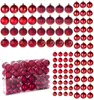 A collection of red Christmas ornaments in various styles, some in a clear plastic box and others arranged in rows. Podgląd zdjęcia produktu