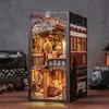 A detailed miniature model of a scene, possibly from a train, with figures and furniture, displayed on a wooden surface. Voir les images du produit
