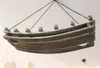 A wooden wine rack shaped like a boat, suspended from the ceiling by chains. Produktbild-Vorschau