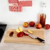 Apples are being prepared on a wooden cutting board next to a bottle of apple cider. Náhľad obrázku produktu