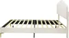 Side view of a beige upholstered bed frame with a slatted mattress support. Produktbild-Vorschau