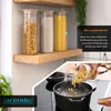 Kitchen scene showing glass storage containers on a shelf and pasta being poured into a pot of boiling water. Anteprima dell’immagine prodotto