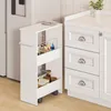 A white rollwagen with two shelves filled with various items, placed next to a white kitchen cabinet. Voir les images du produit