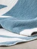 A close-up view of a folded blue and white striped blanket. Anteprima dell’immagine prodotto