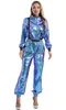 A woman wearing a metallic blue and purple jumpsuit. Produktbild-Vorschau