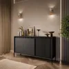 A modern living room with a black sideboard and decorative items. Produktbild-Vorschau